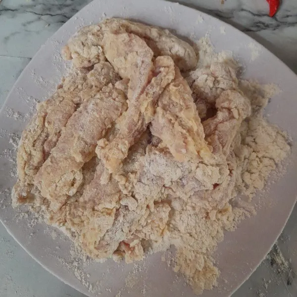 Baluri ayam dengan tepung kering, lakukan hingga bahan habis.
