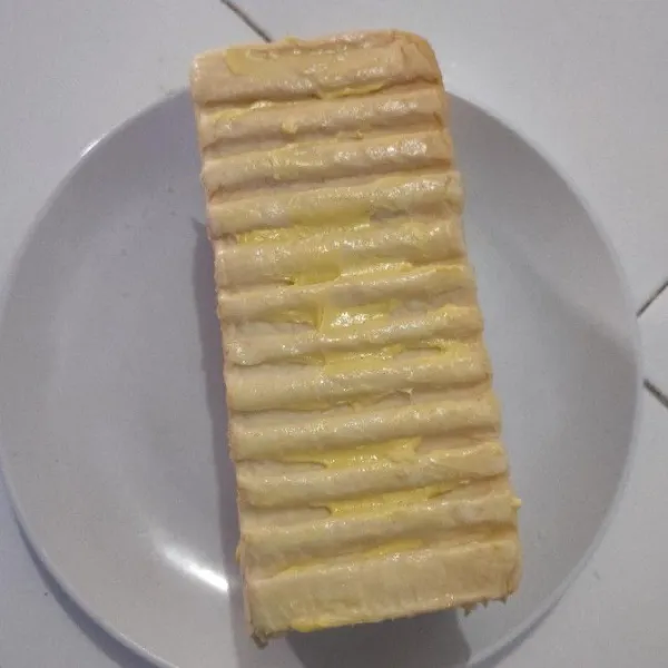 Lalu oles semua sisi permukaan roti dengan margarin.