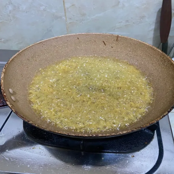 Panaskan minyak dengan api besar lalu masukkan 7 sdm adonan kremesan kurang lebih 30 cm dari atas panci.