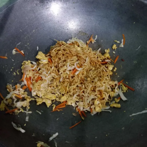 Masukkan mie goreng yang telah dicampur bumbu, aduk-aduk hingga tercampur rata.