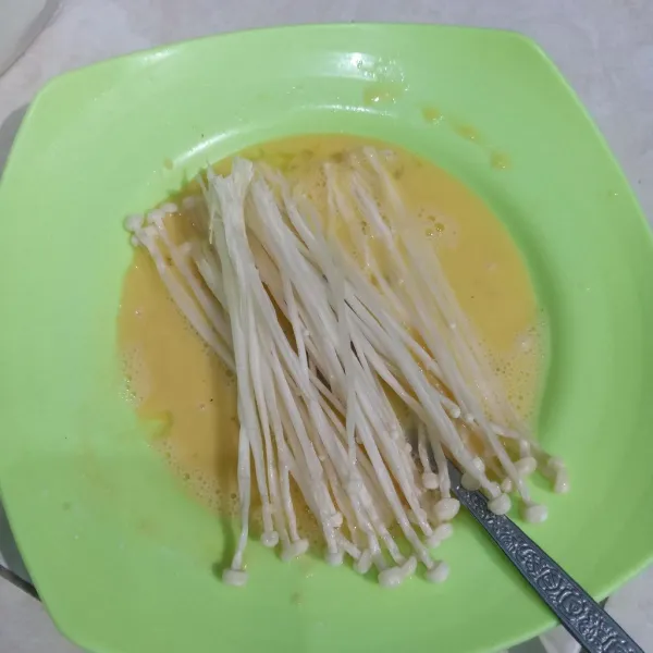 Masukkan jamur enoki dalam pelapis basah.