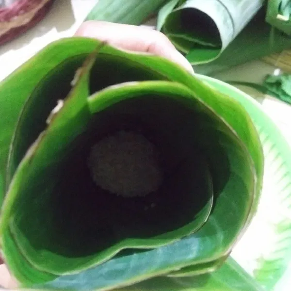 Masukkan beras kira-kira setengah bagian, lalu semat ujung satunya.