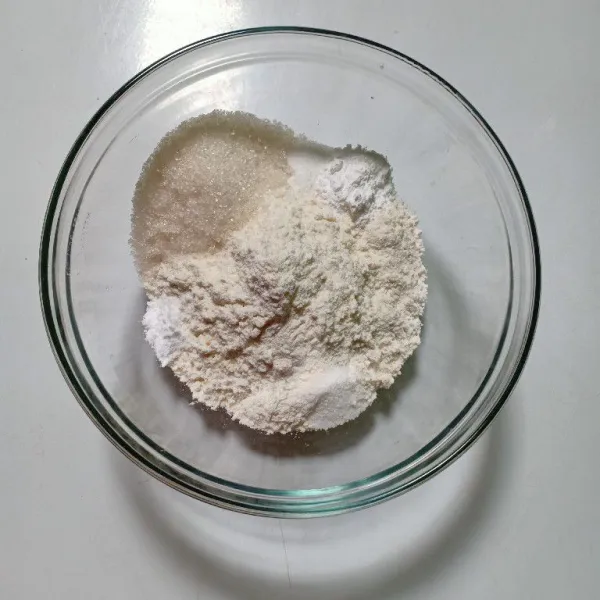 Dalam wadah masukkan tepung terigu, gula pasir, baking powder, baking soda, vanili bubuk dan garam. Aduk merata.
