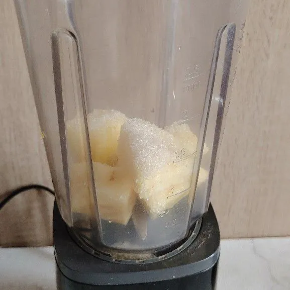 Masukan beberapa potongan nanas kedalam blender, tambahkan gula pasir dan air.