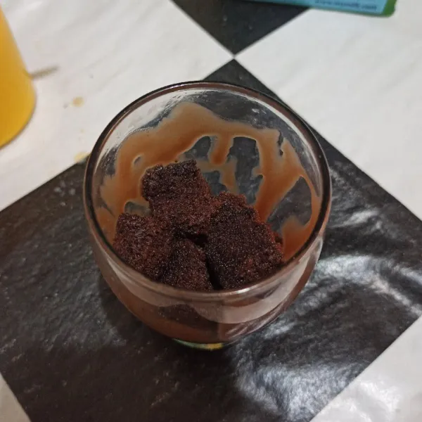 Masukkan brownies yang sudah dipotong kecil ke gelas saji.