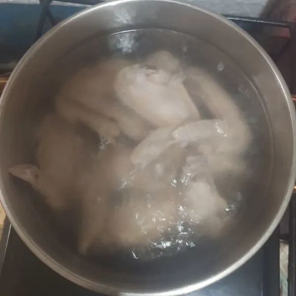 Rebus sayap ayam. Buang air rebusan yang pertama lalu rebus lagi dengan air yang baru.