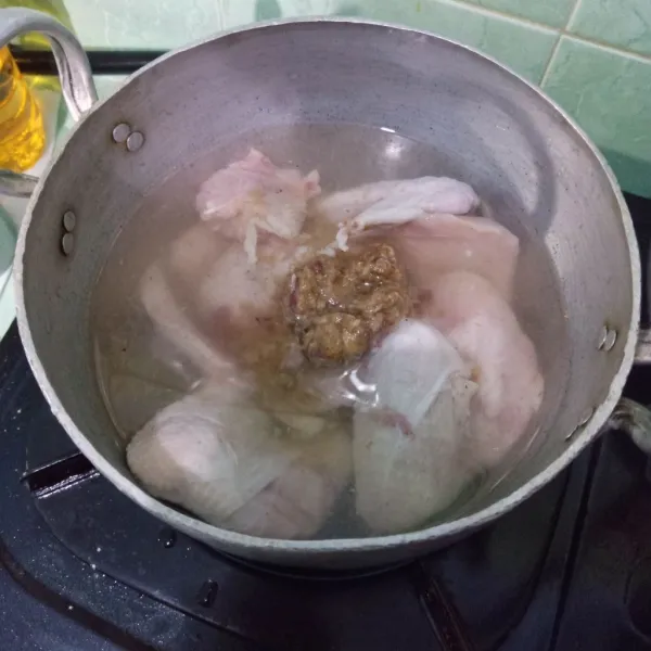 Masukkan ayam dalam panci, beri air dan bumbu halus.