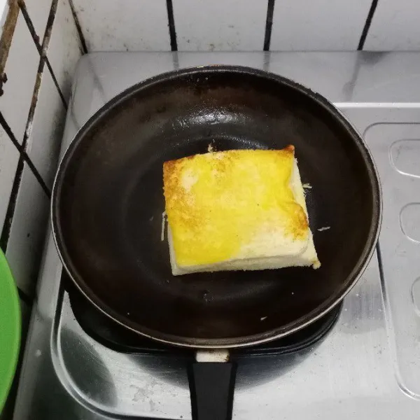 Lelehkan margarin di teflon. Panggang roti hingga kecoklatan.