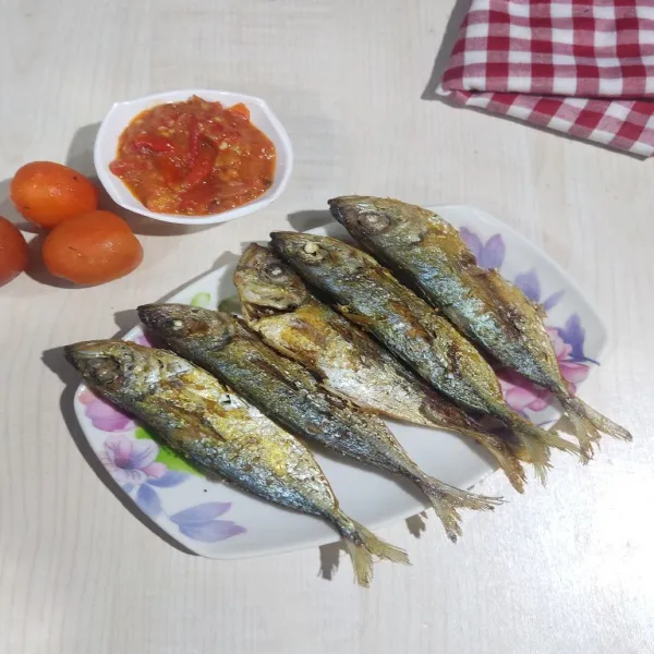 Sajikan ikan goreng dengan sambal tomat.