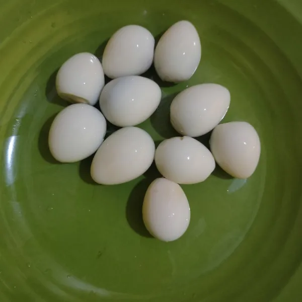 Rebus telur puyuh hingga matang, kupas kulitnya.