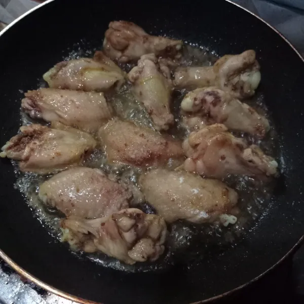 Panaskan minyak, taburi tepung bumbu lalu masukkan sayap ayam, goreng sampai kering keemasan.