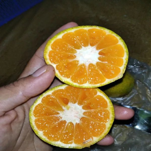 Potong jeruk menjadi 2.