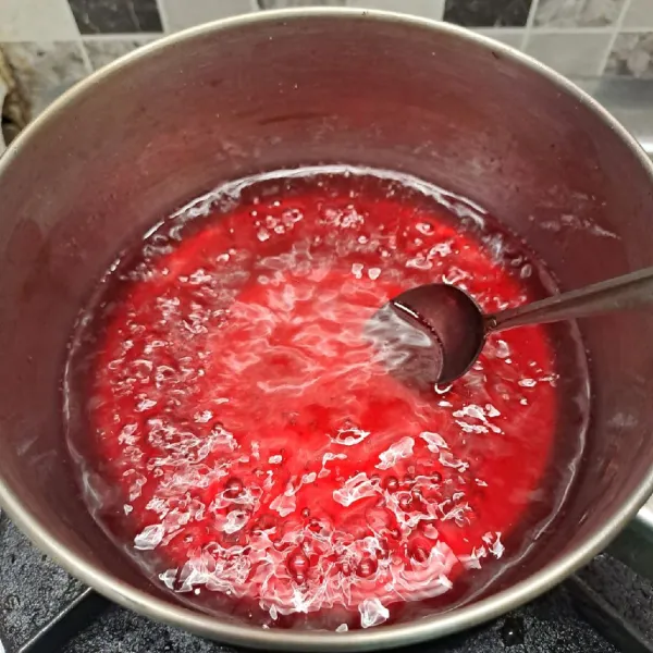 Kecilkan kompor, beri essence doger dan pewarna merah. Aduk sampai rata. Masak sekitar 5 menit. Kemudian matikan kompor. Tunggu sampai sirup dingin.