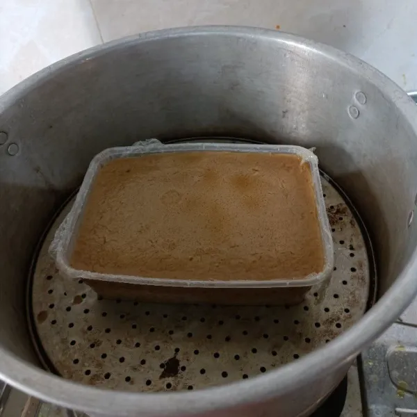 Matikan api kompor. Keluarkan kue dari kukusan biarkan dingin. Setelah dingin baru dikeluarkan dari wadah dengan mengangkat plastik wrap yang tadi dilebihkan.