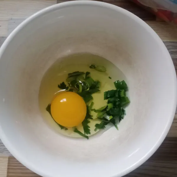 Dalam wadah masukkan telur, daun bawang dan seledri.