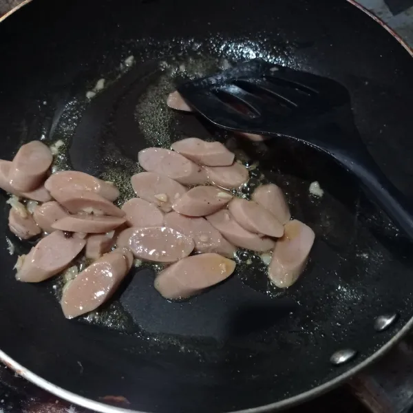 Masukkan sosis, aduk rata masak sampai sosis matang.