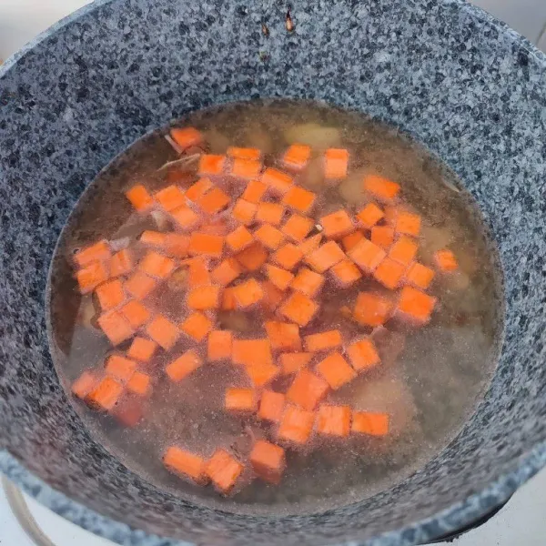 Masukkan wortel dan air. Rebus hingga wortel empuk.