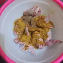 Lumuri sayap ayam dengan bumbu ayam instan, ketumbar bubuk dan merica bubuk, aduk rata.