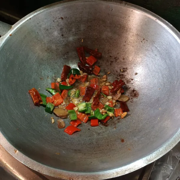 Tumis bawang putih sampai harum, lalu masukan, cabe kering, cabe merah dan cabe ijo. Aduk.