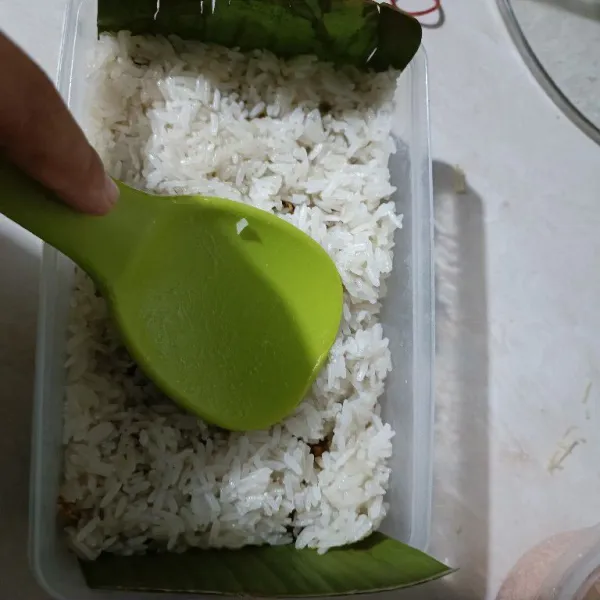 Timpa kembali dengan sisa ketan. Padatkan.