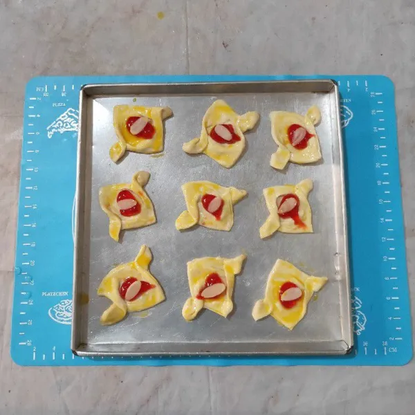 Tata cookies diatas loyang, lalu oles pinggiran puff pastry dengan bahan olesan. Panggang dengan oven suhu 200°C selama 25-30 menit atau sampai matang sesuaikan dengan oven masing-masing.