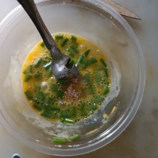 Kocok telur dengan irisan daun bawang juga garam dan lada.