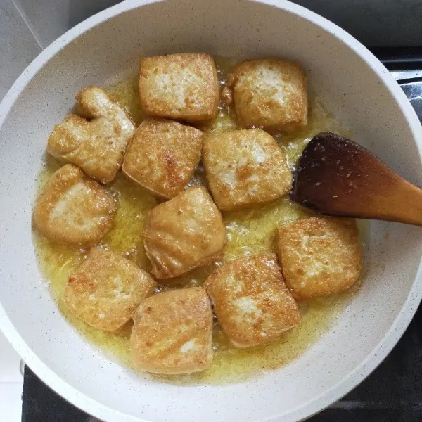 Goreng tahu hingga berkulit kuning keemasan lalu angkat dan tiriskan.