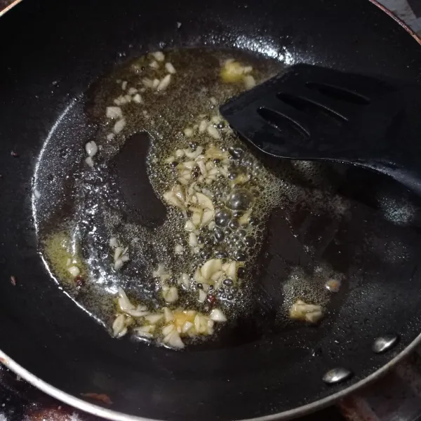 Panaskan mentega, tumis bawang putih sampai layu.