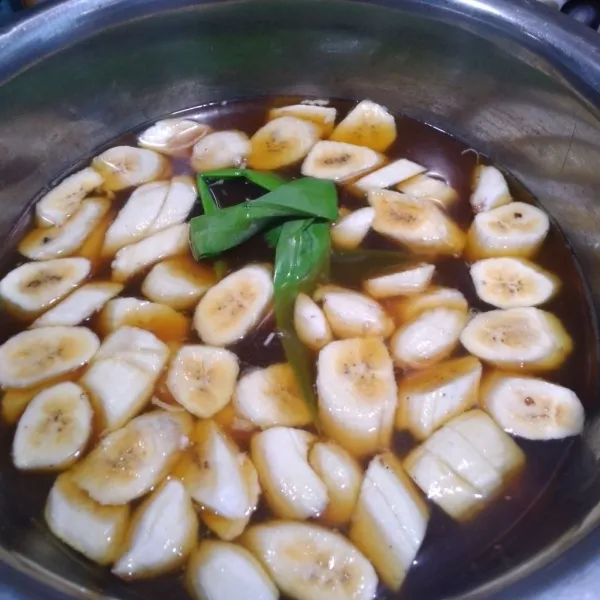 Masukkan potongan pisang dalam rebusan air gula merah.