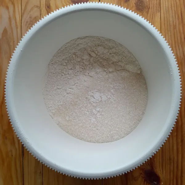 Siapkan wadah, masukkan tepung terigu, gula pasir dan garam, aduk.