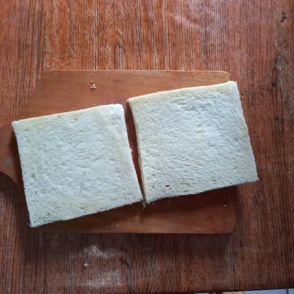 Potong pinggiran roti tawar kemudian belah hingga menjadi 4 bagian.