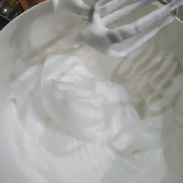 Mixer putih telur bersama cream of tartar hingga berbusa lalu masukkan gula halus secara bertahap 3-4x tahap masukkan gula halus, mixer dengan kecepatan tinggi hingga putih telur kaku / firm peak (medium peak).