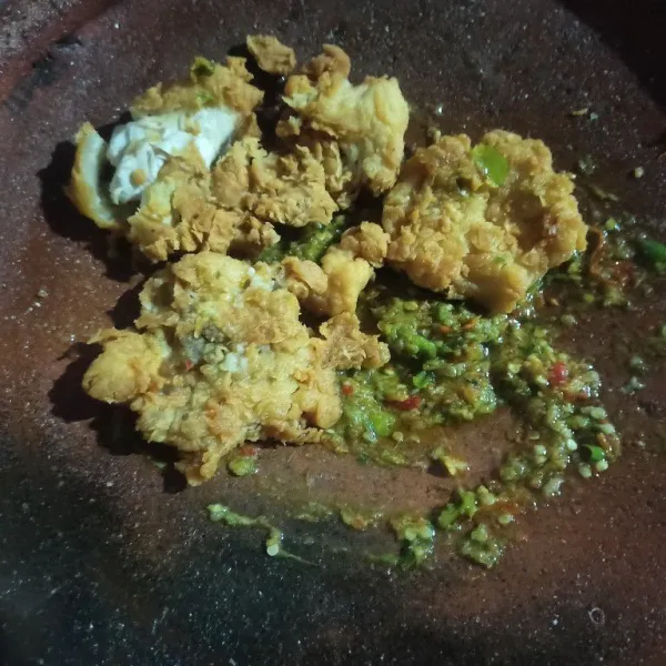Selanjutnya tambahkan ayam dan geprek menggunakan ulekan.