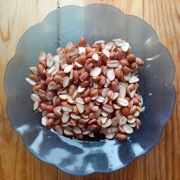 Belah kacang tanah menjadi 2 bagian, sisihkan.