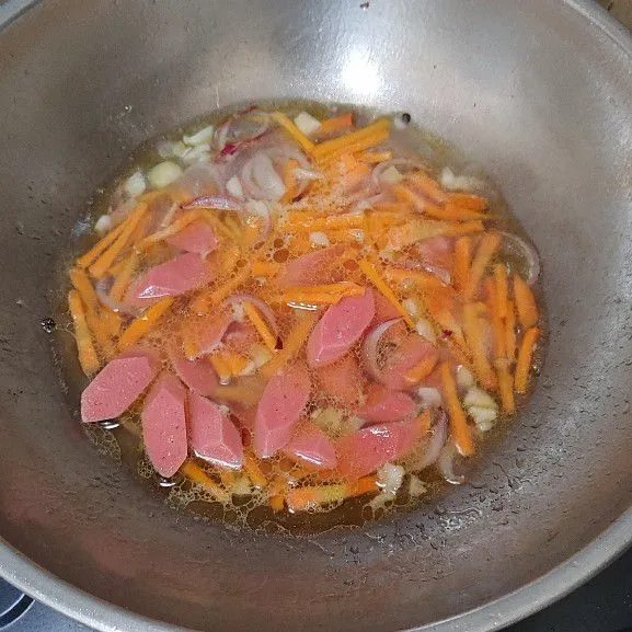 Masukan wortel aduk rata, tambahkan air masak sampai mendidih lalu masukan sosis.