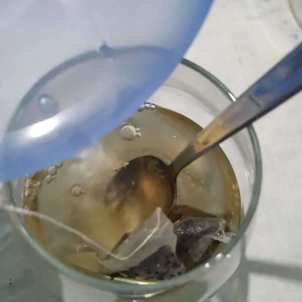 Tuang air hangat ke dalam gelas, lalu aduk hingga gula larut.