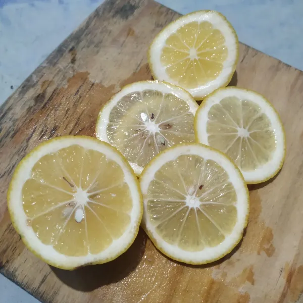 Cuci bersih lemon lalu iris tipis.