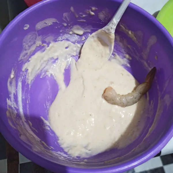Masukkan udang, pegang buntutnya lalu lumuri tepung.