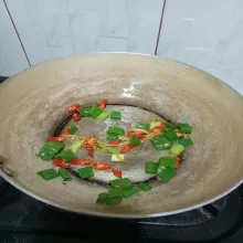 Tambahkan cabe iris dan daun bawang, aduk rata.