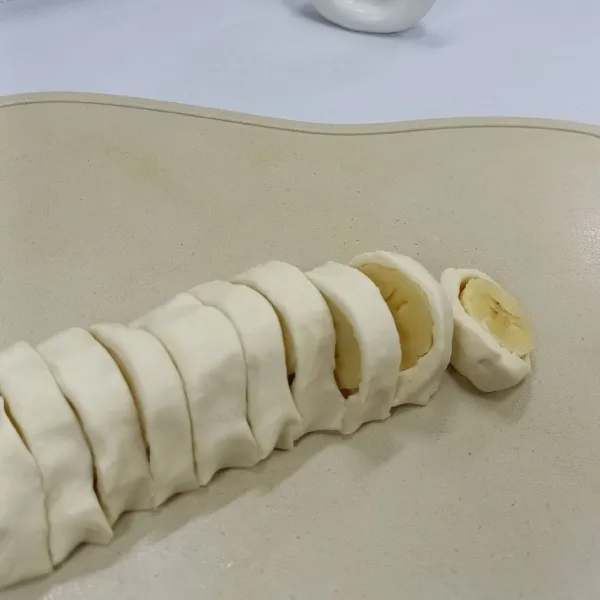 Gulung-gulung sampai pisang tertutupi, lalu potong.