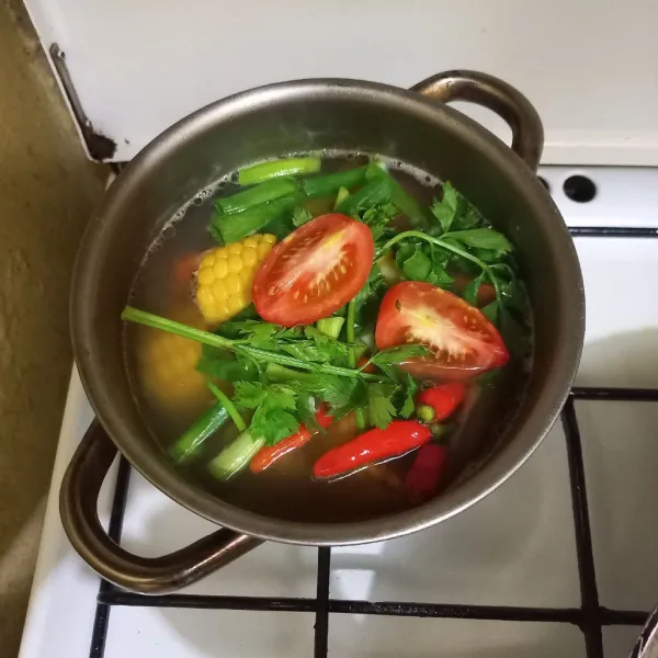 Masukkan irisan bawang daun, tomat, seledri dan cabe rawit utuh
