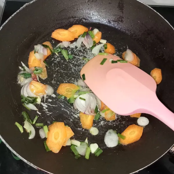 Tumis bawang hingga harum lalu masukkan wortel, tambahkan air lalu aduk rata.