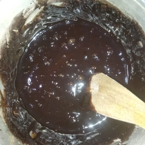 Lalu masukkan tepung terigu dan coklat bubuk sambil diayak, aduk rata dengan sendok kayu atau spatula.