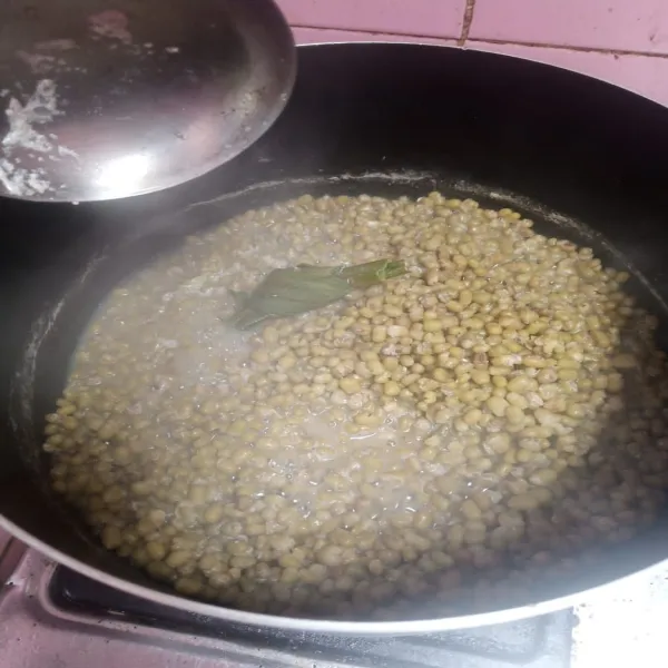 Rebus kacang ijo yang sudah direndam semalaman dengan daun pandan, sampai kacang ijo merekah.
