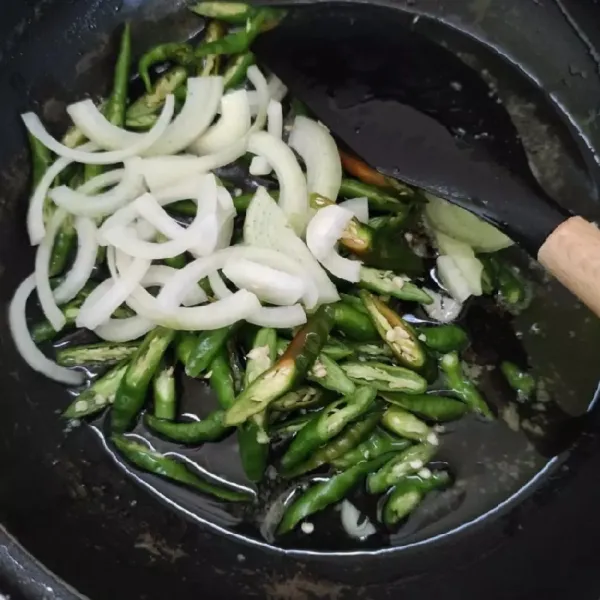 Panaskan minyak, tumis bawang bombay dan cabai hijau sampai harum.