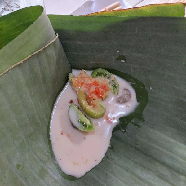 Siapkan daun,letakan udang ,tomat iris,lalu tambahkan kuah santan secukupnya, bungkus, semat dengan lidi