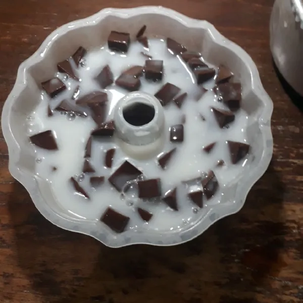 Tuang setengah puding susu ke dalam cetakan, masukkan puding coklat yang sudah dipotong - potong, tuang kembali sisa puding susu hingga cetakan penuh.