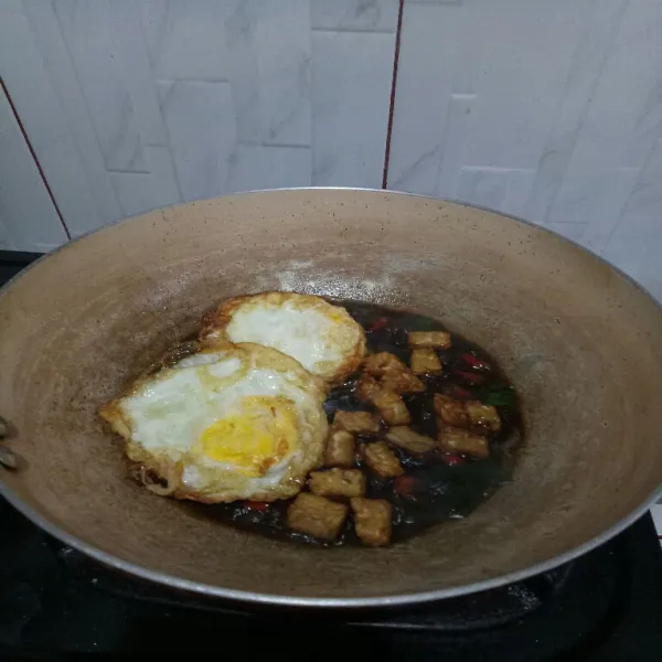 Masukkan telur ceplok dan tempe masak hingga bumbu meresap.