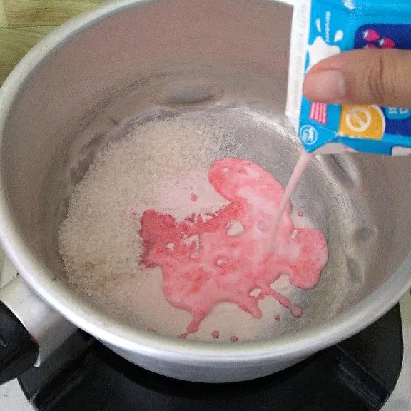 Tuang susu rasa strawberry dan air .