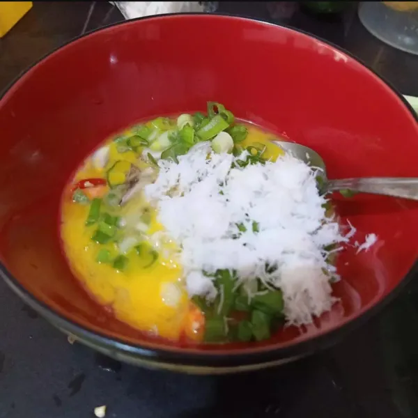 Dalam mangkok, masukkan 3 butir telur, tambahkan juga irisan bawang merah, cabe merah besar, daun bawang